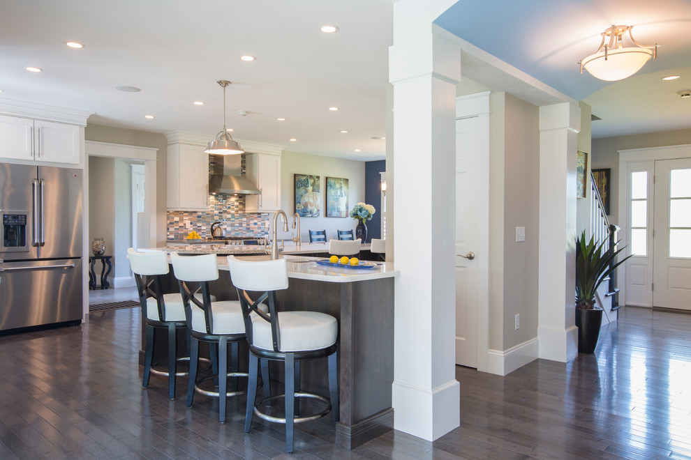 Inspiration for a large transitional u-shaped dark wood floor and brown floor eat-in kitchen remodel with an undermount sink, recessed-panel cabinets, dark wood cabinets, quartz countertops, multicolored backsplash, matchstick tile backsplash, stainless steel appliances, two islands and white countertops