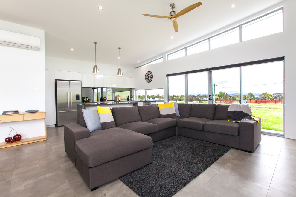 This is an example of a contemporary open concept living room in Hobart with white walls.