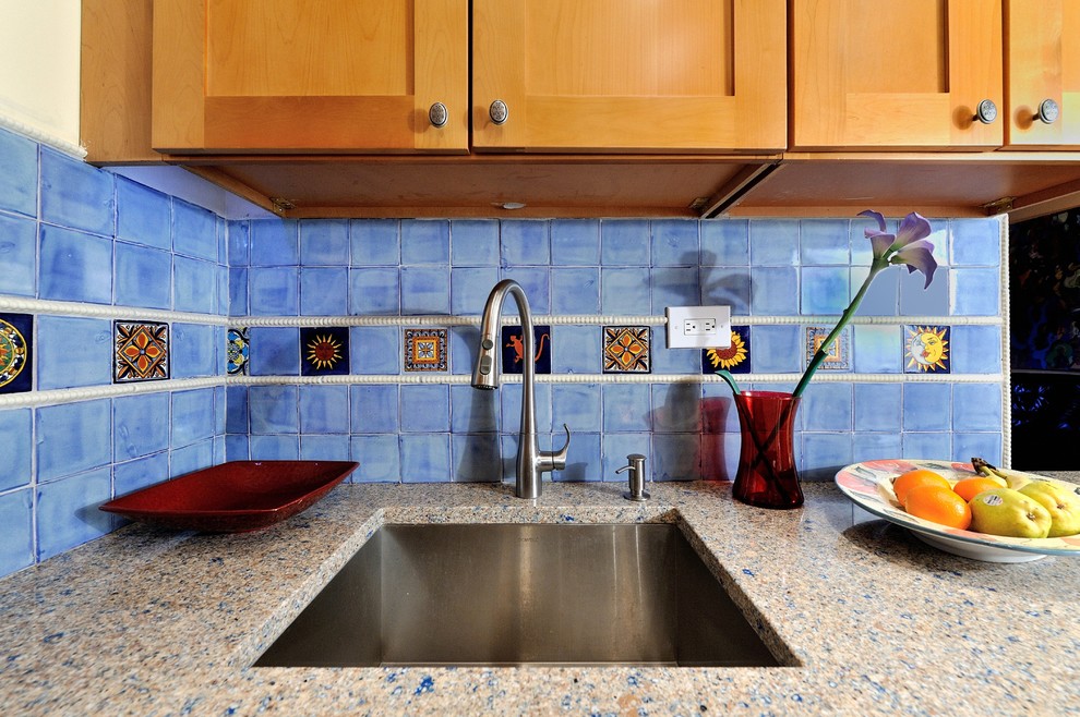 Источник вдохновения для домашнего уюта: маленькая отдельная, п-образная кухня в средиземноморском стиле с фасадами с выступающей филенкой, светлыми деревянными фасадами, синим фартуком, фартуком из керамической плитки, техникой из нержавеющей стали, столешницей из переработанного стекла, полом из керамогранита и врезной мойкой для на участке и в саду