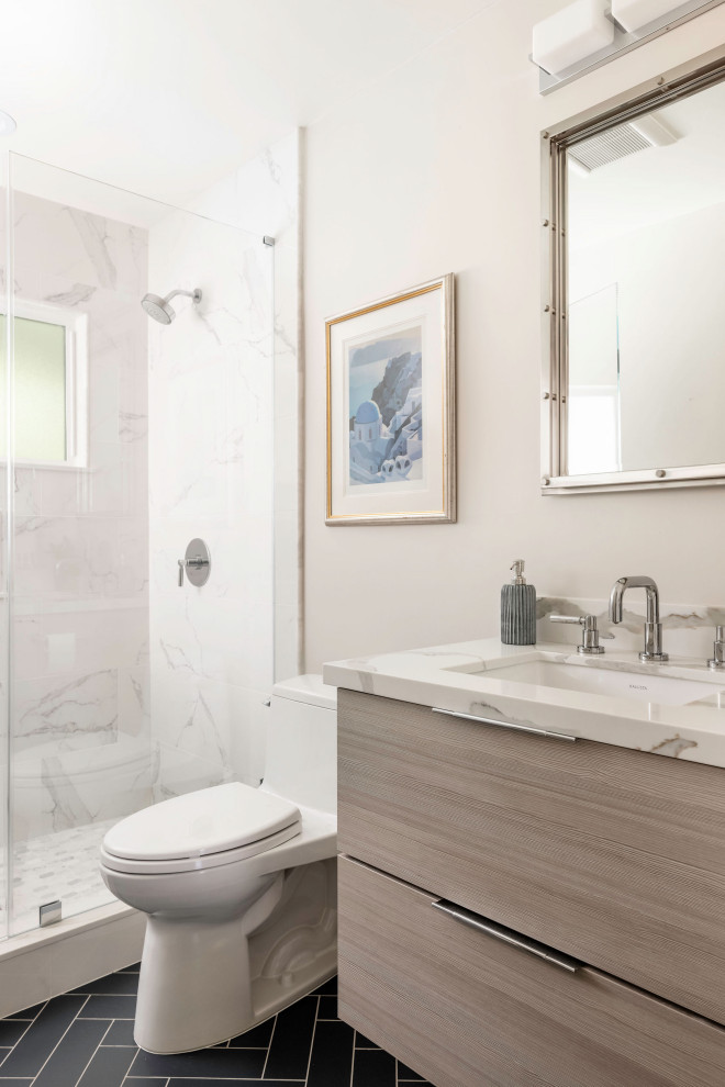Small coastal bathroom in San Francisco with flat-panel cabinets, light wood cabinets, an alcove shower, a one-piece toilet, porcelain tiles, beige walls, ceramic flooring, a submerged sink, engineered stone worktops, blue floors, a hinged door, grey worktops, a single sink and a floating vanity unit.