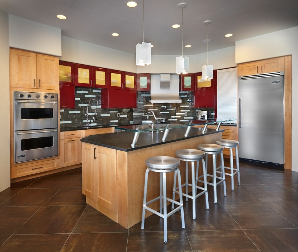 Inspiration for a mid-sized modern l-shaped eat-in kitchen in Phoenix with an undermount sink, glass-front cabinets, red cabinets, quartz benchtops, grey splashback, glass tile splashback, stainless steel appliances, ceramic floors and with island.