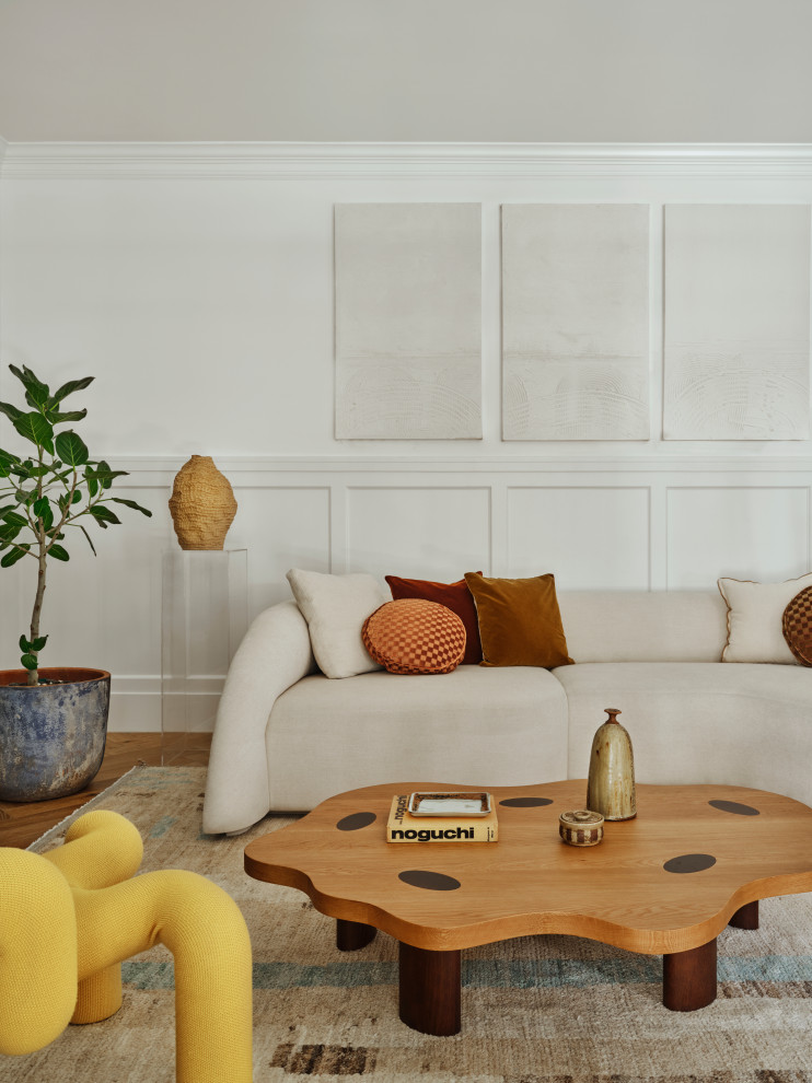 На фото: гостиная комната в стиле неоклассика (современная классика) с белыми стенами, паркетным полом среднего тона, коричневым полом и панелями на стенах