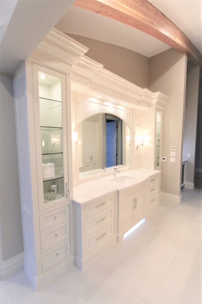 Photo of an expansive traditional bathroom in Calgary with white cabinets, beige walls, porcelain floors, an integrated sink, white floor, white benchtops, a single vanity, a built-in vanity and exposed beam.