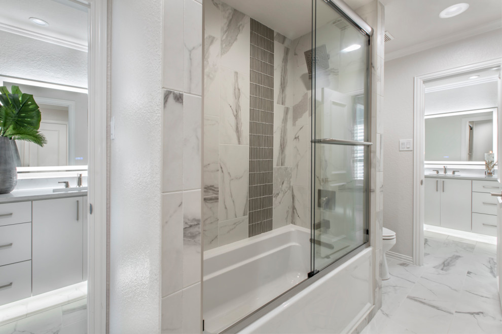 Свежая идея для дизайна: ванная комната среднего размера в стиле модернизм с плоскими фасадами, белыми фасадами, ванной в нише, душем над ванной, раздельным унитазом, серой плиткой, керамической плиткой, серыми стенами, полом из керамической плитки, врезной раковиной, столешницей из кварцита, белым полом, душем с раздвижными дверями, белой столешницей, тумбой под одну раковину и встроенной тумбой - отличное фото интерьера