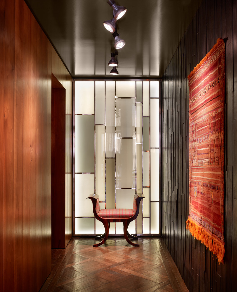 Photo of a midcentury hallway in Austin with brown walls, dark hardwood floors and brown floor.