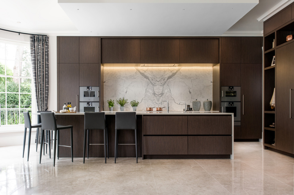 This is an example of a large contemporary kitchen in Surrey with flat-panel cabinets, dark wood cabinets, with island and white benchtop.