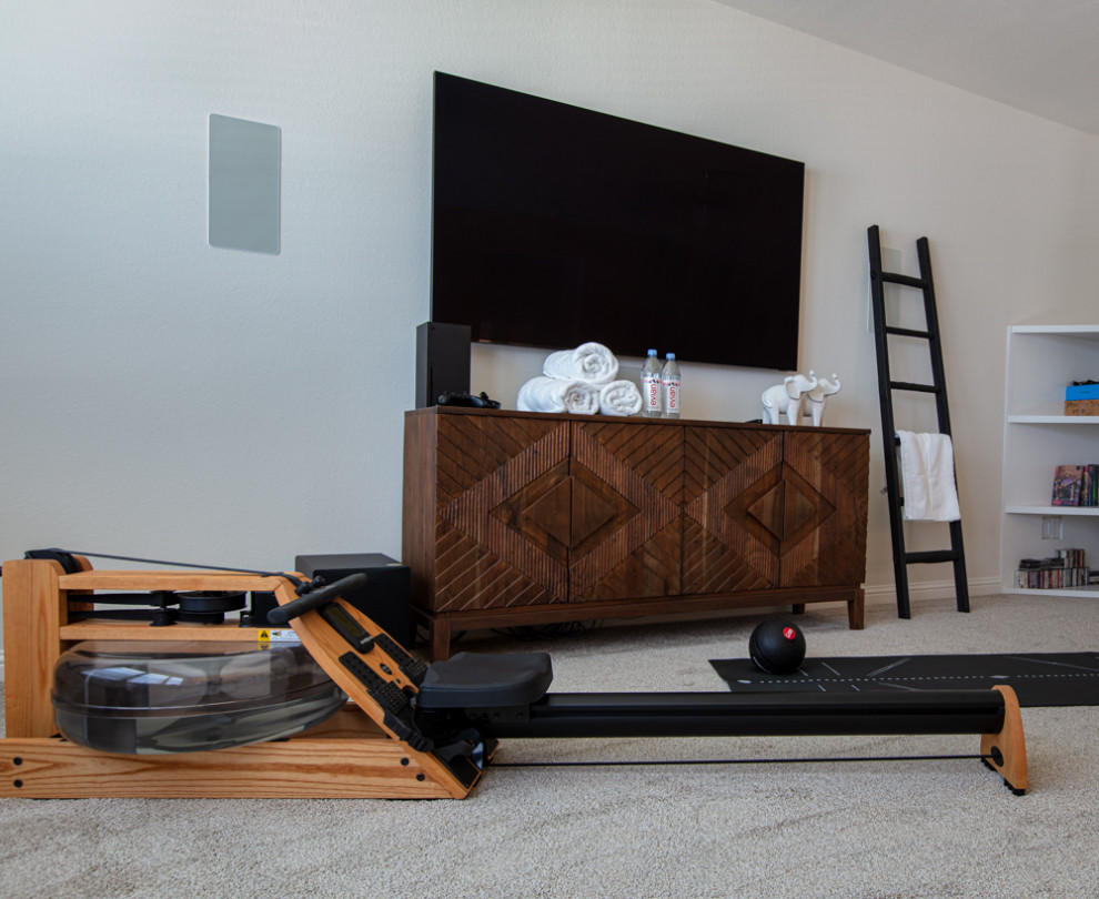This is an example of a large modern multi-use home gym in Houston with beige walls, carpet and beige floors.