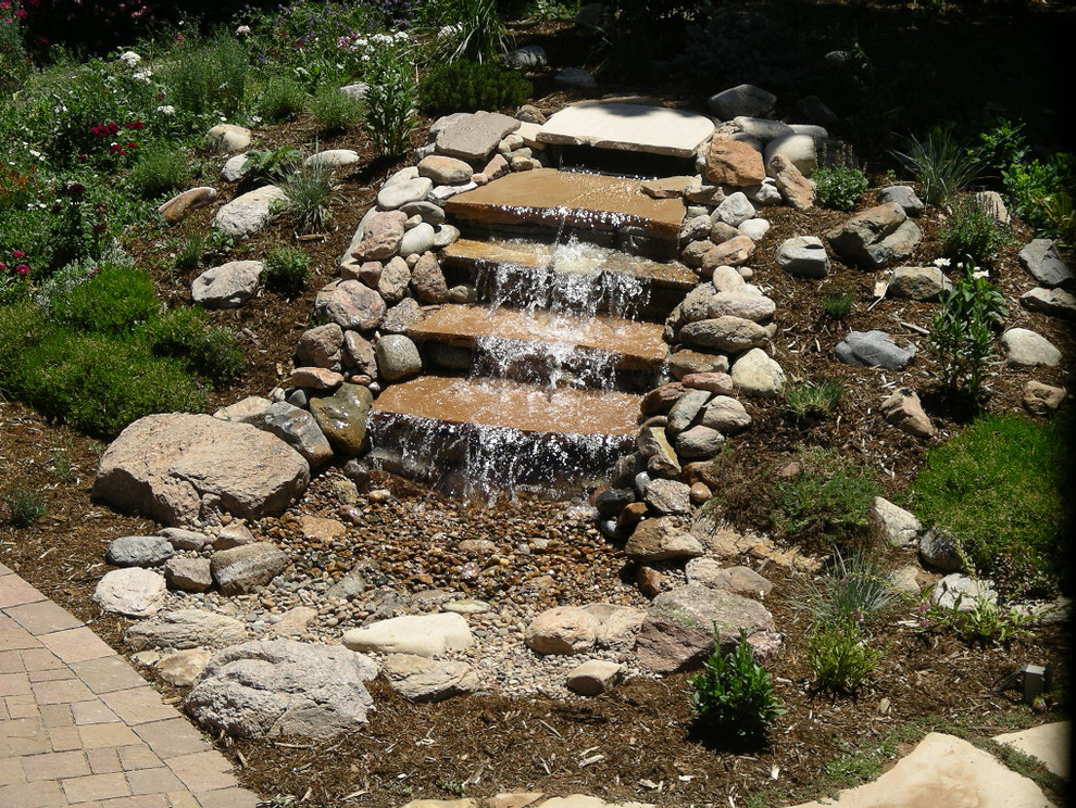 Backyard garden in Denver with with waterfall and river rock.