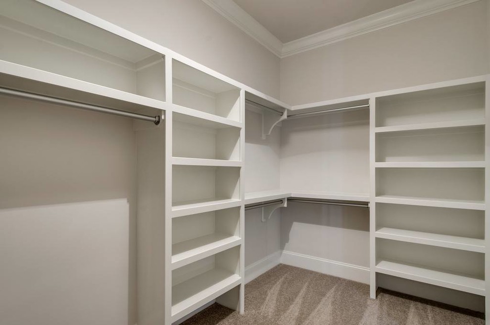 Photo of a mid-sized transitional gender-neutral walk-in wardrobe in Other with open cabinets, white cabinets, carpet and beige floor.