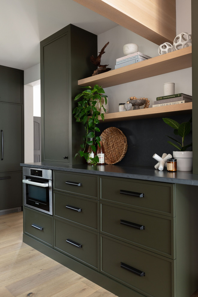 Inspiration for a large contemporary u-shaped eat-in kitchen in Toronto with flat-panel cabinets, green cabinets, soapstone benchtops, white splashback, panelled appliances, black benchtop and with island.