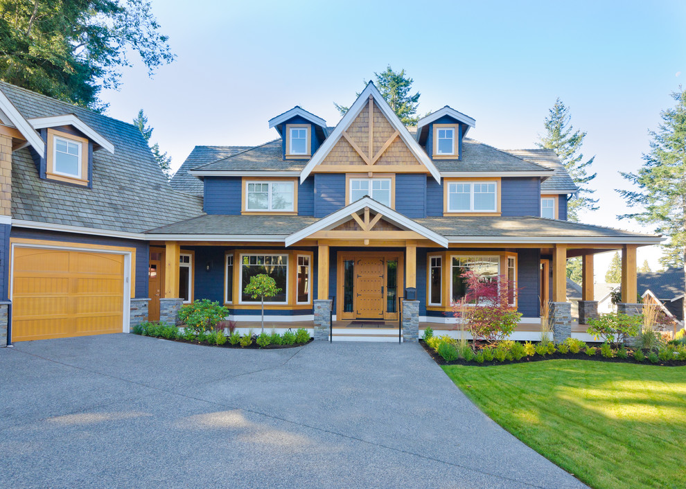 This is an example of a mid-sized arts and crafts two-storey blue house exterior in Other with wood siding, a hip roof and a shingle roof.