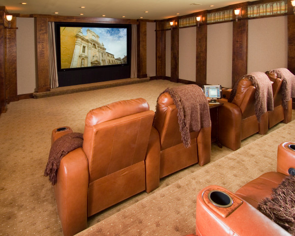Photo of a mid-sized traditional enclosed home theatre in Other with white walls, carpet and a wall-mounted tv.