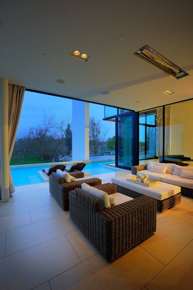 Patio - large modern backyard concrete paver patio idea in San Francisco with a roof extension