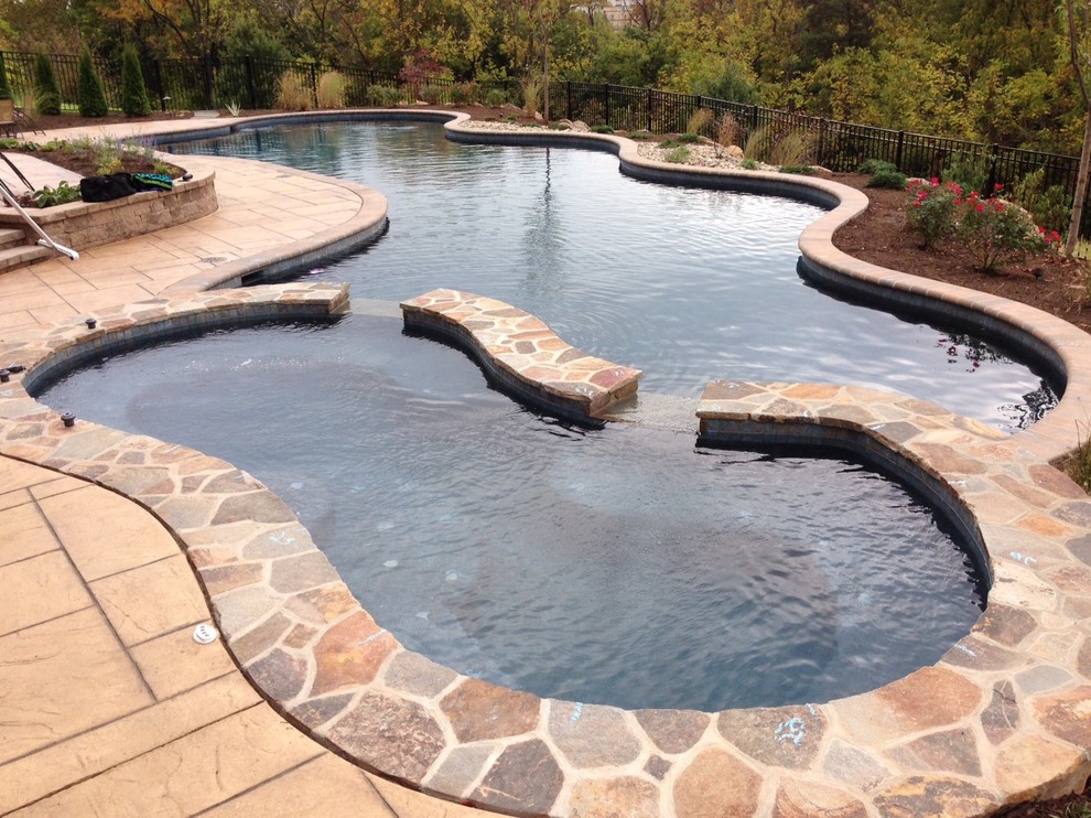 Large country backyard custom-shaped natural pool in Philadelphia with a hot tub and natural stone pavers.