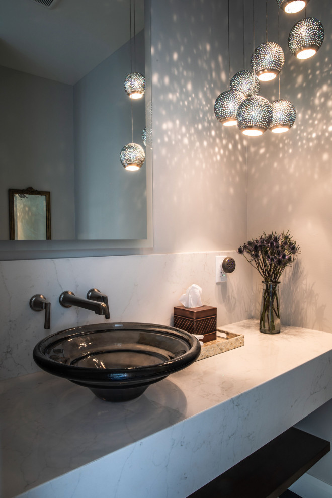 Idée de décoration pour un petit WC et toilettes minimaliste avec un mur gris, une vasque, un plan de toilette blanc et meuble-lavabo suspendu.
