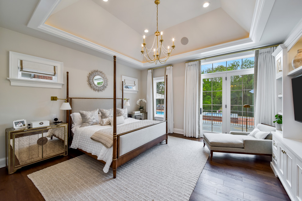Ejemplo de dormitorio principal clásico grande con paredes beige, suelo de madera en tonos medios, suelo marrón y bandeja