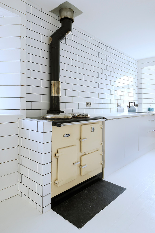Scandinavian kitchen in Other with flat-panel cabinets, white cabinets, white splashback and subway tile splashback.