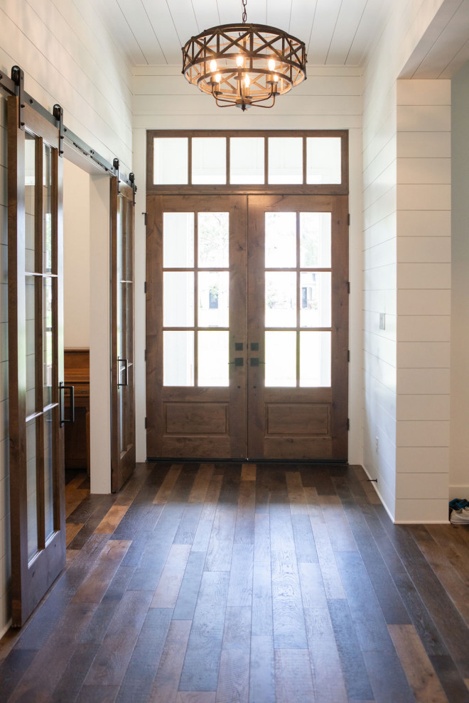 Großes Landhausstil Foyer mit weißer Wandfarbe, braunem Holzboden, Doppeltür, hellbrauner Holzhaustür, braunem Boden, Holzdielendecke und Holzdielenwänden in Houston
