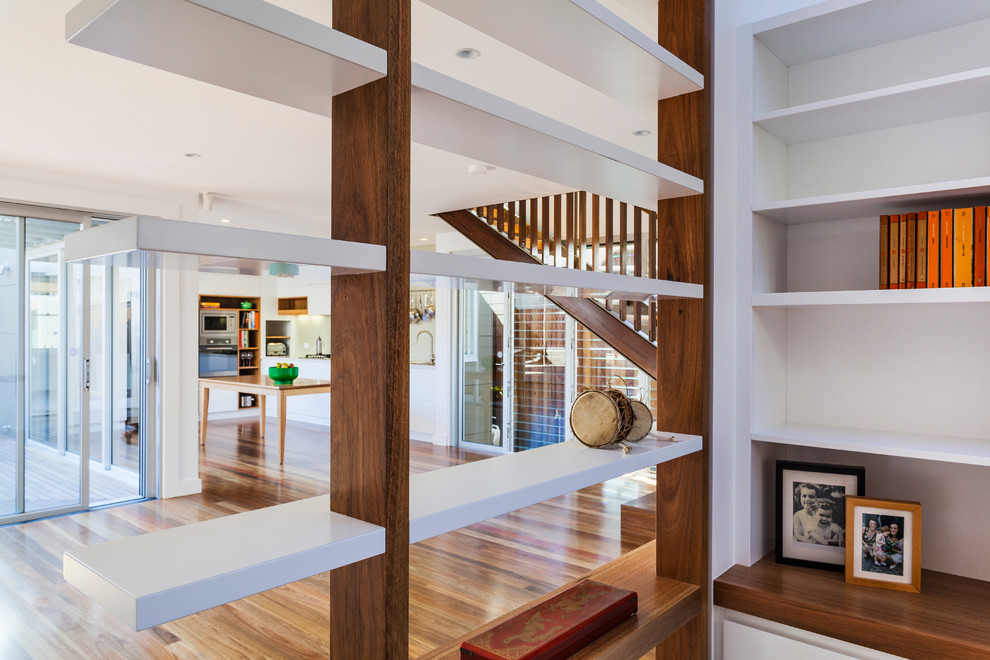 This is an example of a contemporary living room in Sydney with white walls and medium hardwood floors.