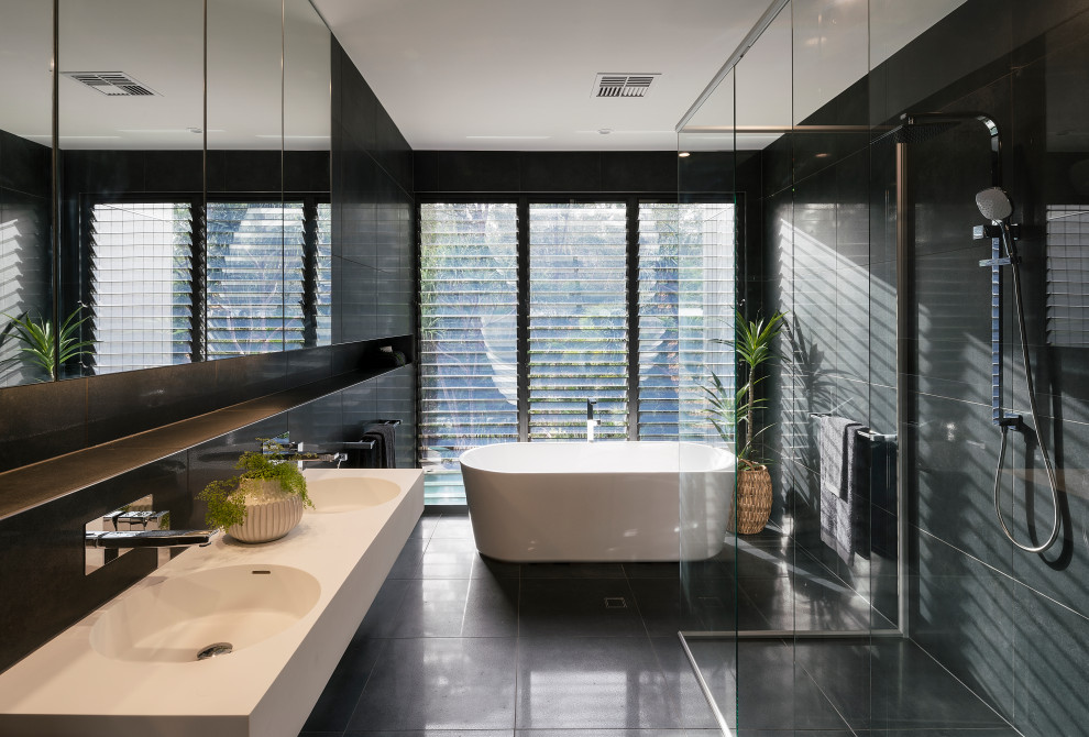 Inspiration for a contemporary master bathroom in Sunshine Coast with white cabinets, a freestanding tub, a curbless shower, black tile, an integrated sink, black floor, an open shower, white benchtops, a double vanity and a floating vanity.