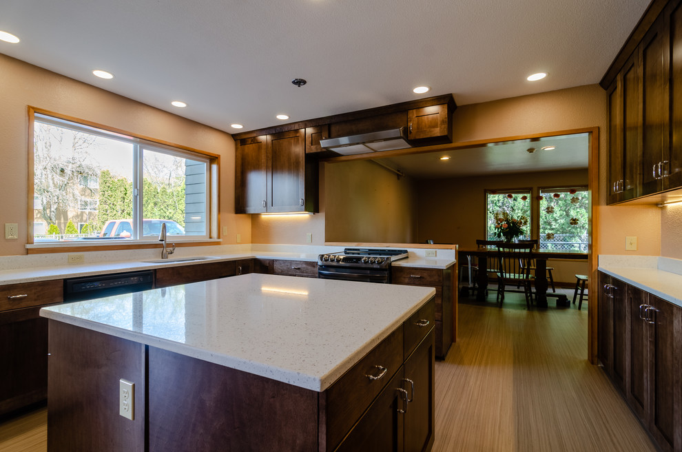 Large transitional u-shaped light wood floor and beige floor enclosed kitchen photo with an undermount sink, recessed-panel cabinets, dark wood cabinets, quartz countertops, stainless steel appliances, an island and white countertops