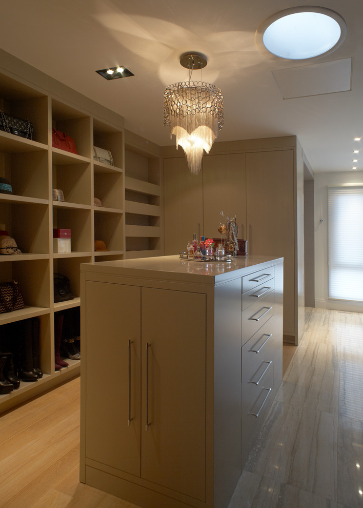 Photo of a contemporary dressing room in Toronto with flat-panel cabinets, beige cabinets and light hardwood floors.