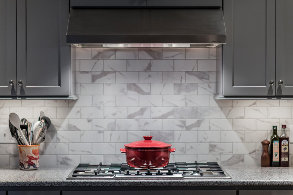 Eat-in kitchen - large transitional single-wall dark wood floor eat-in kitchen idea in Boston with an undermount sink, flat-panel cabinets, gray cabinets, granite countertops, white backsplash, ceramic backsplash, stainless steel appliances and an island