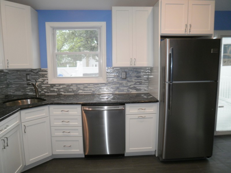 Inspiration for a contemporary eat-in kitchen in Miami with glass tile splashback.
