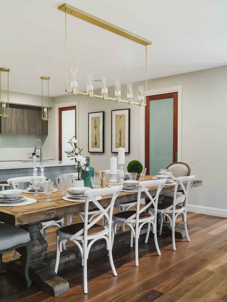 Transitional kitchen/dining combo in Melbourne with beige walls, medium hardwood floors and brown floor.