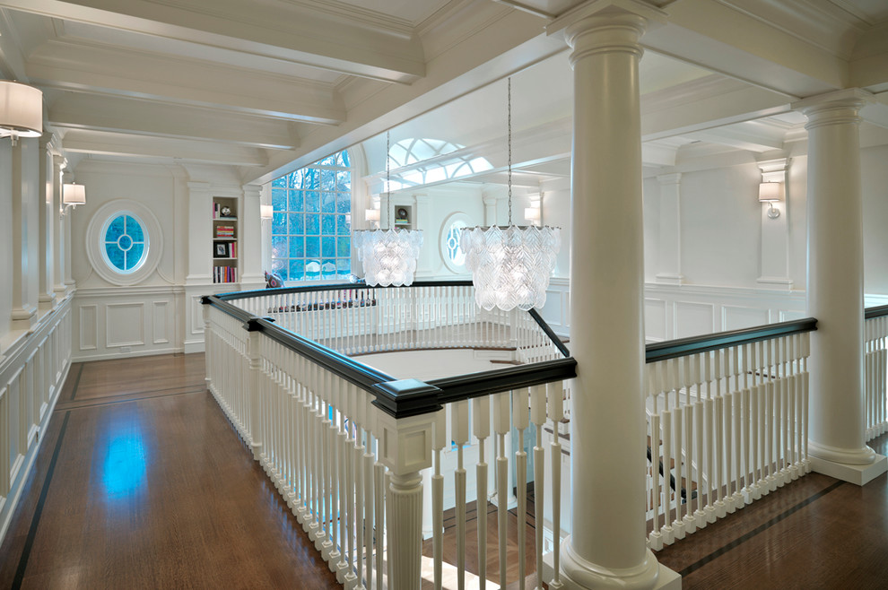 Photo of a traditional hallway in Boston with white walls, dark hardwood floors and brown floor.