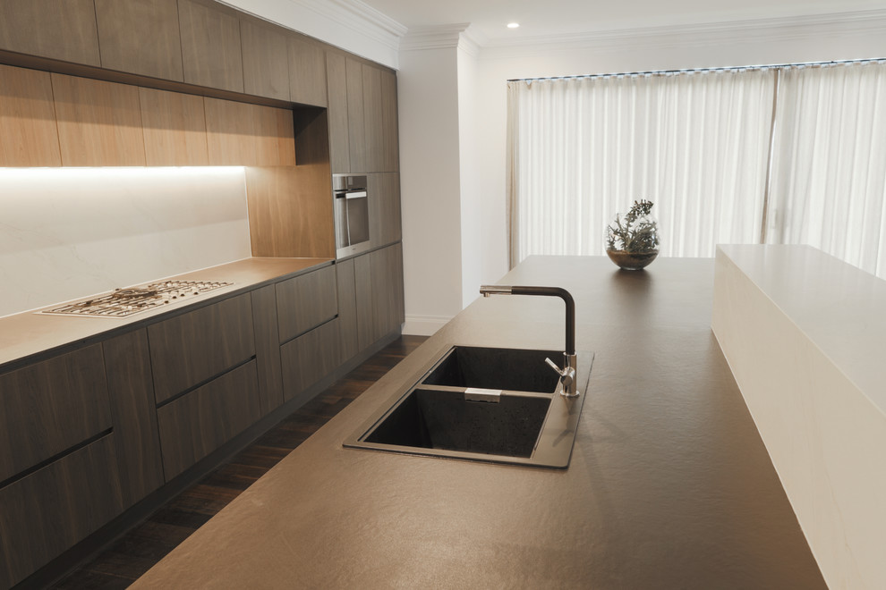 Design ideas for a mid-sized modern galley eat-in kitchen in Sydney with a double-bowl sink, flat-panel cabinets, dark wood cabinets, quartz benchtops, white splashback, stone slab splashback, stainless steel appliances, laminate floors, with island, brown floor and black benchtop.