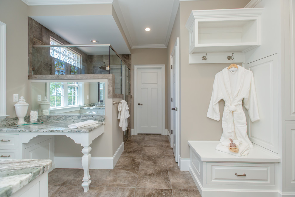 Photo of a traditional bathroom in Atlanta with raised-panel cabinets, white cabinets, brown tile and beige walls.