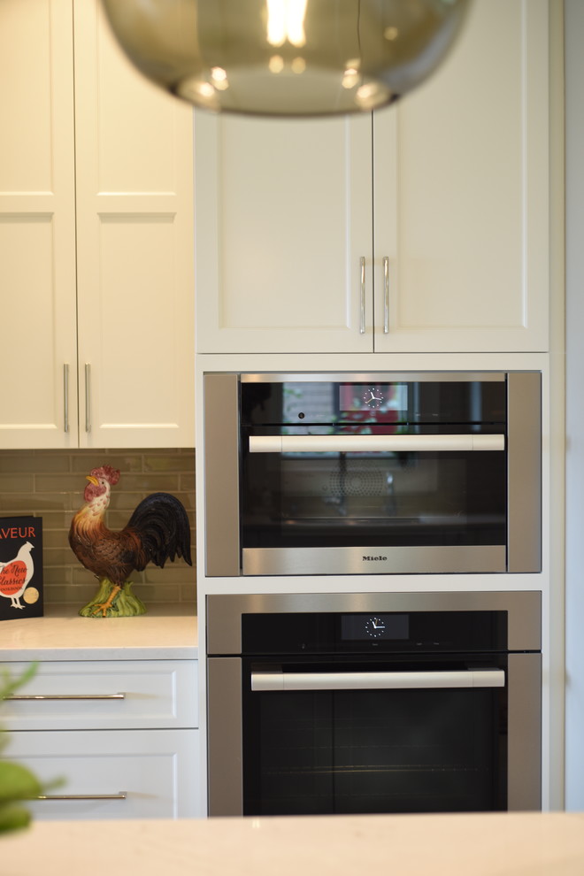 Example of a transitional ceramic tile kitchen design in Seattle with shaker cabinets, white cabinets, quartzite countertops, subway tile backsplash, stainless steel appliances, an island and white countertops