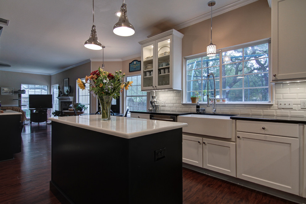 Traditional u-shaped eat-in kitchen in Austin with a farmhouse sink, flat-panel cabinets, white cabinets, quartz benchtops, white splashback, subway tile splashback and stainless steel appliances.