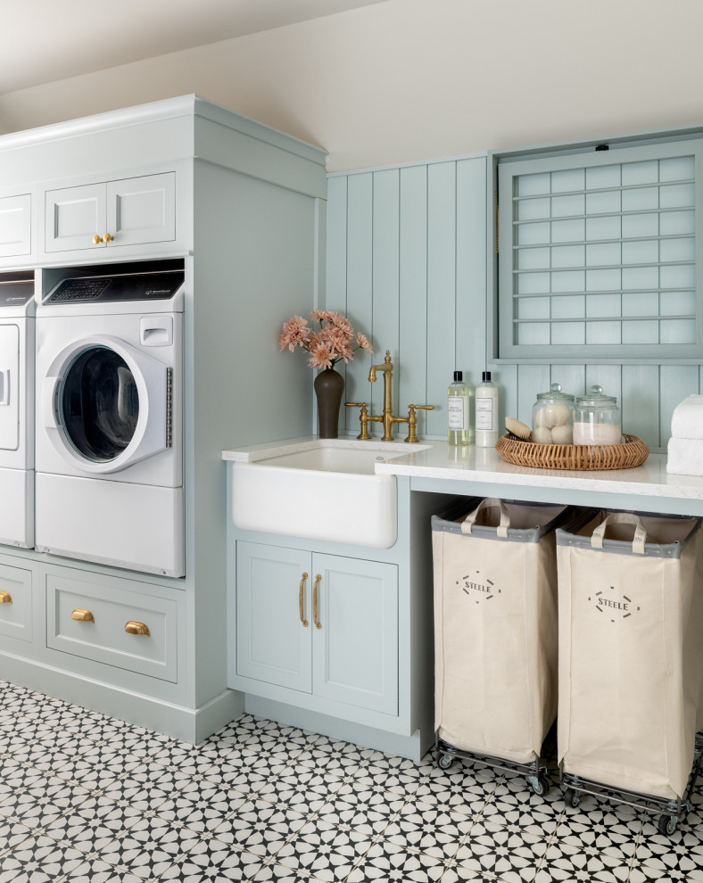 Laundry room - transitional single-wall multicolored floor and shiplap wall laundry room idea in Philadelphia with a farmhouse sink, recessed-panel cabinets, blue cabinets, blue walls, a side-by-side washer/dryer and white countertops