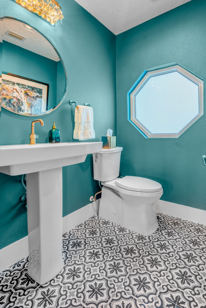 Réalisation d'un petit WC et toilettes tradition avec un mur bleu, un sol en carrelage de céramique, un sol multicolore et meuble-lavabo sur pied.