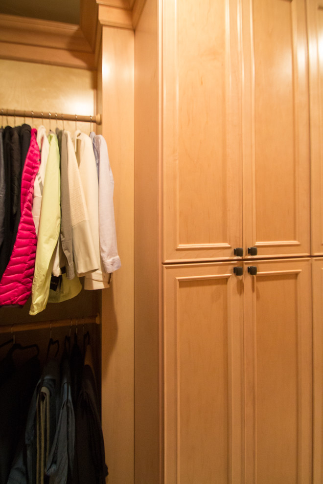 Large traditional gender-neutral walk-in wardrobe in Denver with raised-panel cabinets, light wood cabinets, travertine floors and beige floor.