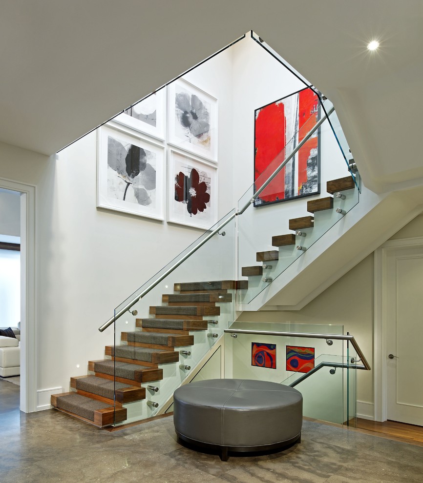 Design ideas for a large contemporary wood u-shaped staircase in Toronto with wood risers and glass railing.