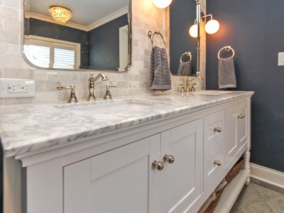 Inspiration for a large transitional master bathroom in Charlotte with shaker cabinets, white cabinets, a freestanding tub, a corner shower, a two-piece toilet, beige tile, stone tile, blue walls, porcelain floors, an undermount sink, marble benchtops, brown floor and a hinged shower door.