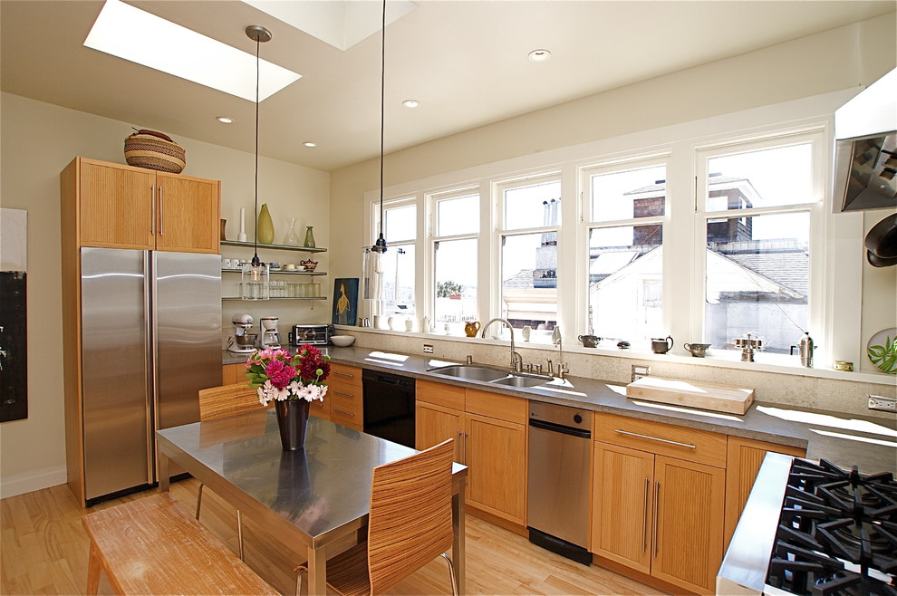 This is an example of a contemporary u-shaped eat-in kitchen in San Francisco with an undermount sink, light wood cabinets and stainless steel appliances.