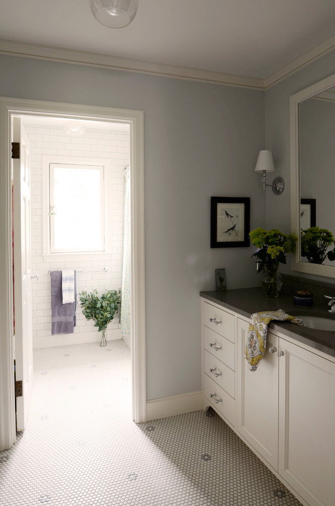 This is an example of a large traditional kids bathroom in Portland with shaker cabinets, white cabinets, white tile, subway tile, grey walls, mosaic tile floors, an undermount sink, engineered quartz benchtops, a shower/bathtub combo, a one-piece toilet and white floor.