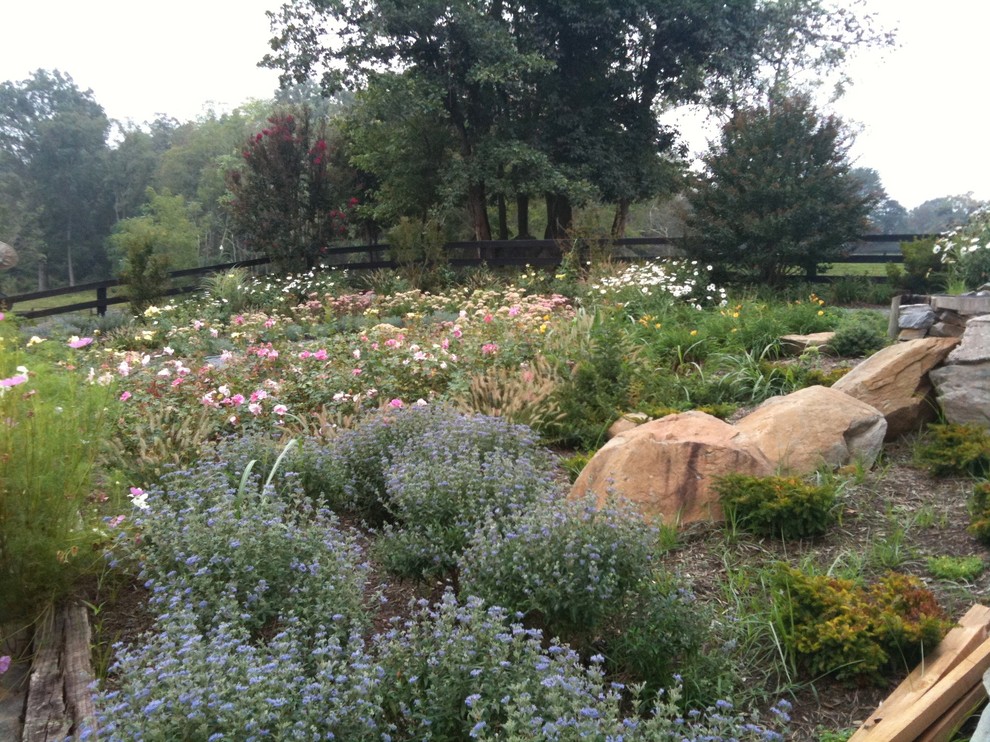 Photo of a large rustic partial sun backyard stone formal garden for summer.