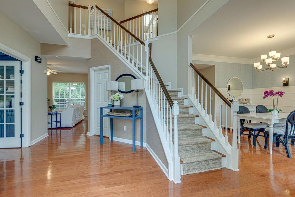 This is an example of an expansive transitional foyer in Nashville with beige walls, medium hardwood floors, a single front door, a blue front door and orange floor.