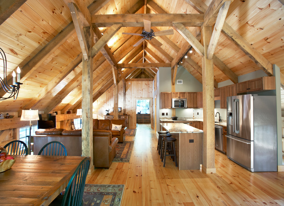 Inspiration for a large rustic l-shaped light wood floor eat-in kitchen remodel with a double-bowl sink, recessed-panel cabinets, light wood cabinets, green backsplash, stainless steel appliances and an island
