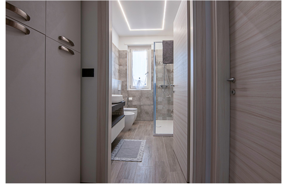Diseño de cuarto de baño único y flotante actual con puertas de armario grises, baldosas y/o azulejos grises, baldosas y/o azulejos de porcelana, aseo y ducha y encimeras grises