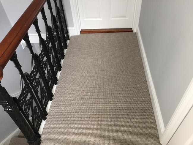 Mid-sized transitional carpeted curved staircase in London with carpet risers and mixed railing.