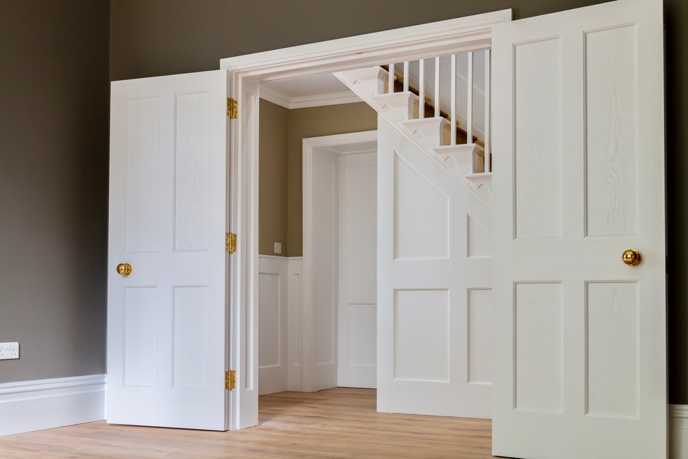 Mid-sized traditional hallway in Kent with white walls, laminate floors and brown floor.