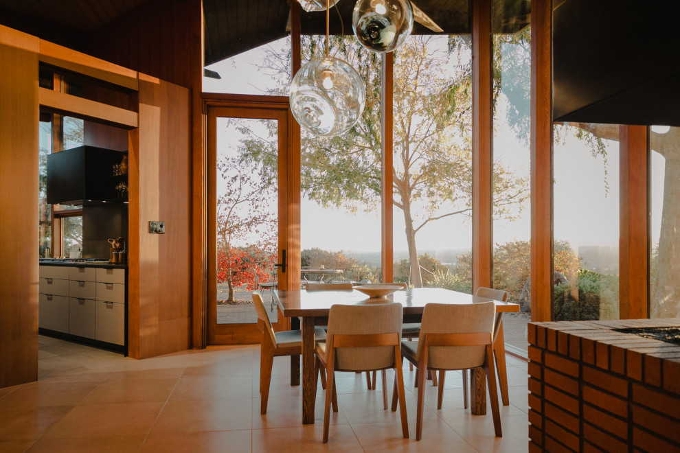 Idée de décoration pour une salle à manger minimaliste en bois fermée et de taille moyenne avec un mur marron, une cheminée d'angle, un manteau de cheminée en brique, un sol beige et un plafond en bois.