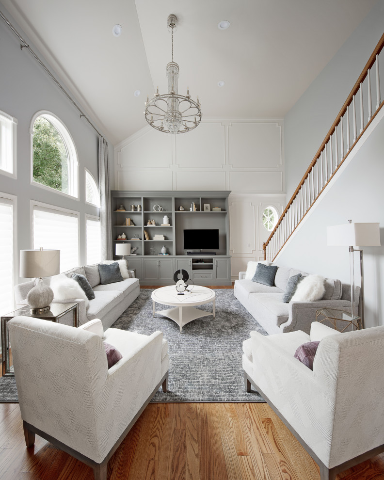 Imagen de salón abierto y abovedado tradicional renovado con paredes grises, suelo de madera en tonos medios, pared multimedia, suelo marrón y panelado