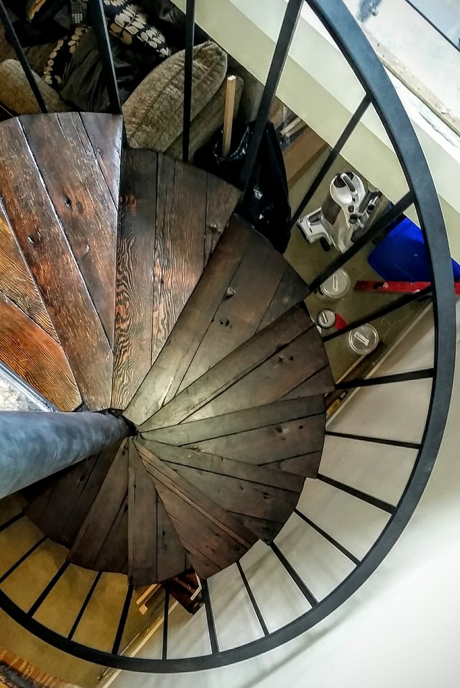 Inspiration for a mid-sized midcentury wood spiral staircase in Seattle with metal risers.